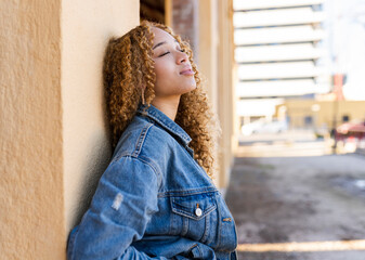 pretty young woman leaning on a wall in the city