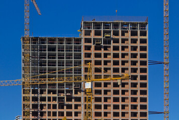 An abstract fragment of a modern construction of a high-rise residential complex. Construction of modern apartment buildings. Blue sky.