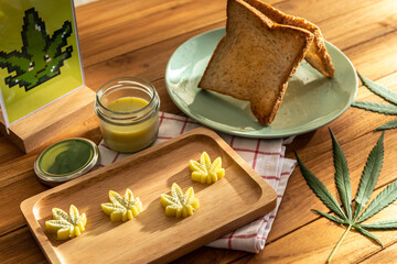 Dish of slide bread toast serve with cannabis butter in cannabis leaves shape in wooden tray on...