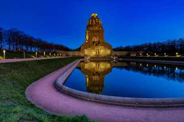 Monument to the Battle of the Nations at sunrise with a lake in the foreground