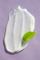 Cosmetic smears of cream with green leaf. Stylish concept of organic creams, health and beauty products. Flat lay. Body and skin care, moisturizing
