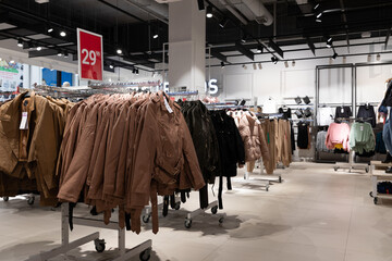 interior of a store selling stylish inexpensive clothes, jackets on hangers in a wide range