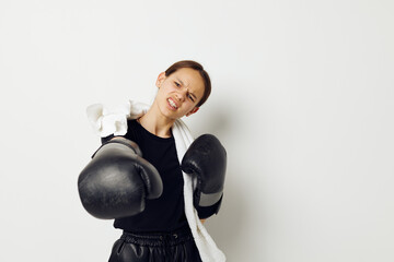 athletic woman in boxing gloves in black pants and a T-shirt isolated background