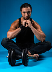 muscular man with dumbbells. sportsman posing in black t-shirt, jeans with dumbbells. studio...