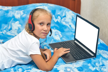 A junior high student looks at a white laptop monitor while at home . Home online education . Computer and information literacy .