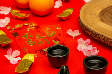 Above view accessories of Chinese new year or Mood day festival oranges gold and Angpao pockets whit cherry blossom branch decorations.