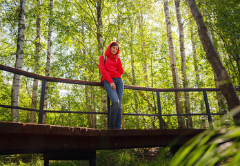 Naklejka na ściany i meble trip to central Russia, St. Petersburg, ecotrail Sestroretsky swamps. regenerative travel concept. Young woman hiking and camping in nature. with backpack walking in green forest