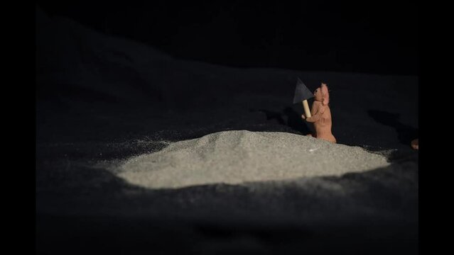 Stop motion animated short of two clay figures excavating a fossil from sand and making a table