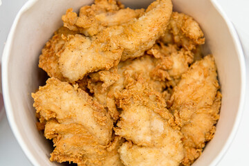 Breaded chicken fillet in bucket. fried chicken strips with take a way bucket