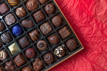 Assorted Luxury Chocolate Box on Red Background, Copy Space