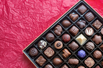 Assorted Luxury Chocolate Box on Red Background, Copy Space