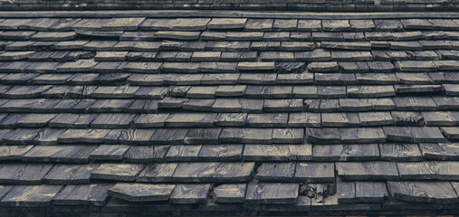 Natural rustic background. Roof of a mountain house with wooden tiles.