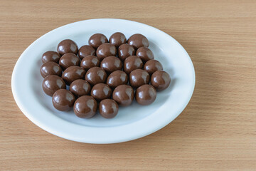 Hazelnuts covered with chocolate on a plate