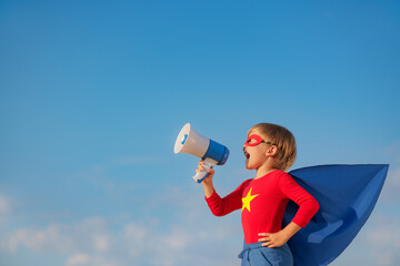 Superhero child against summer sky outdoor