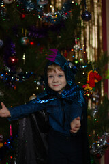 little boy in a dinosaur costume next to the Christmas tree, new year's eve