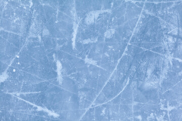 Empty ice rink with skate marks after the session outdoor. skating ice rink texture covered with snow in daylight. Close up of blue ice rink floor, copy space