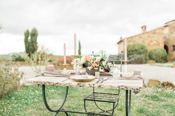 Wedding reception table with flowers and rustic gold and white decoration,  outdoors