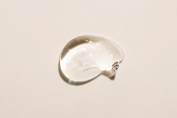 Transparent hyaluronic acid gel on a beige background.