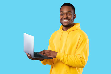 Happy African American Freelancer Guy With Laptop Posing, Blue Background