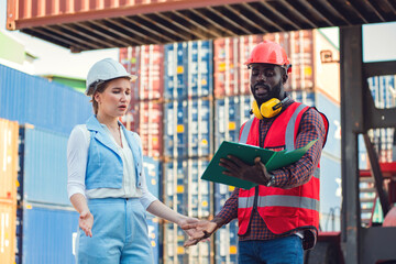 The Problem with businesswoman and engineer talking and checking loading Containers box from Cargo freight ship for import export. shipping in docks.
