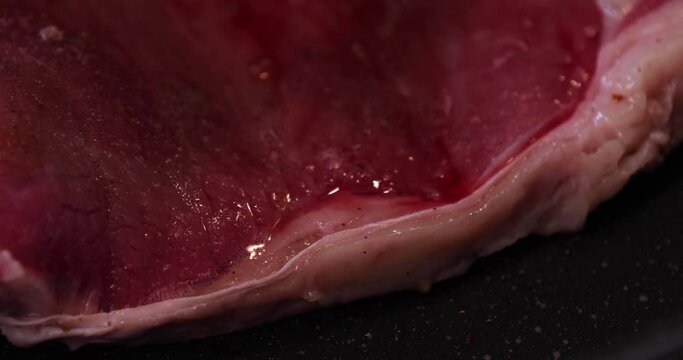A timelapse of grilling T born stake meat on the pan in the kitchen close up