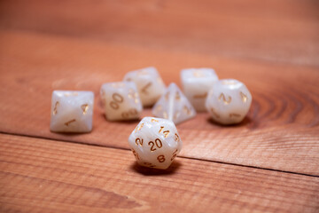 Set of role playing white dices on a gaming table made of wood: background for role-playing games