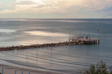 Obraz premium Lido di Venezia. Spiaggia dei Murazzi al tramonto con pennello e persone