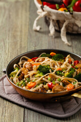 stir-fry pasta with chicken, broccoli and carrots.