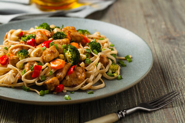 stir-fry pasta with chicken, broccoli and carrots.