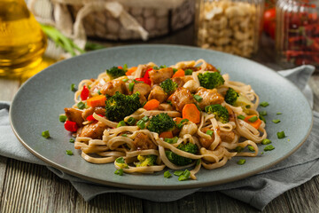 stir-fry pasta with chicken, broccoli and carrots.