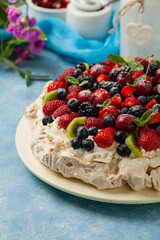 Meringue Pavlova cake with fresh fruit. Front view.