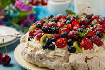 Meringue Pavlova cake with fresh fruit. Front view.