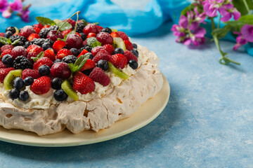 Meringue Pavlova cake with fresh fruit. Front view.