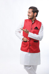 young indian man in traditional wear and giving expression on white background.