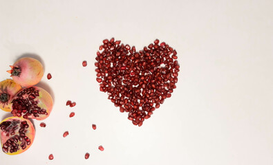 Heart shape made with red pomegranate fruit