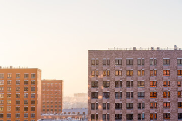 urban modern landscape: multi-colored new buildings residential buildings, windows, air conditioning, facades in winter, sunset