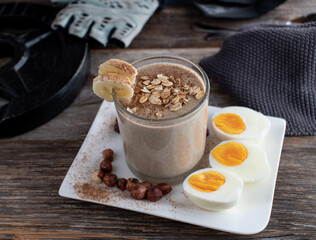Body building breakfast with a chocolate protein drink made with oats, bananas and hazelnuts. Served with boiled eggs. Muscle building meal