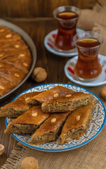Baklava on the table and tea in Turkish glasses. Selective focus.