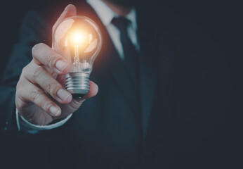 Business hand showing creative business strategy with light bulb as concept, Innovation through ideas and inspiration ideas idea of creativity, Light bulbs ideas the business concept.