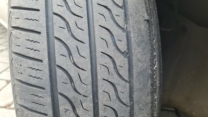 old black tire treads that are broken and worn. time to change tires. Tire tread problem and solution concept.
