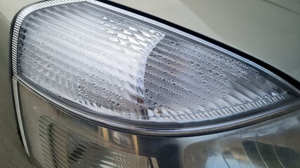 Foggy headlight with condensation in a modern car