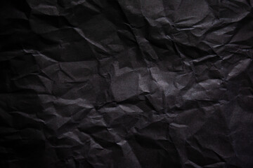 Textured crumpled black paper background.