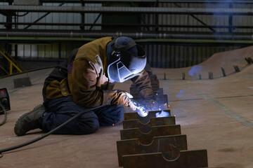 Detailed photo of a welder in a shipyard