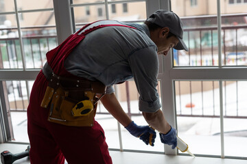 The worker installing and checking window in the house