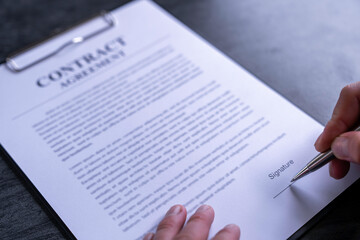 Obraz premium business man reading and signing a business contract, business agreement consensus signing, business concept and signing