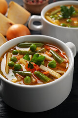 Bowls of tasty turnip soup on dark table