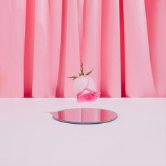 Romantic pink composition with rose flower and mirror on pastel satin background. Trendy minimal Valentine's Day concept.