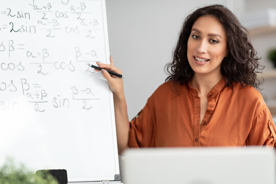 Female teacher explaining trigonometric functions to students using pc