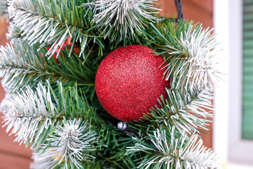 Obraz na płótnie Canvas Christmas decoration. Red ball surrounded by green needles. No people