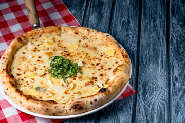 Tasty sliced pizza with fresh arugula and different kinds of cheese. Four cheese pizza, pizza Margarita.